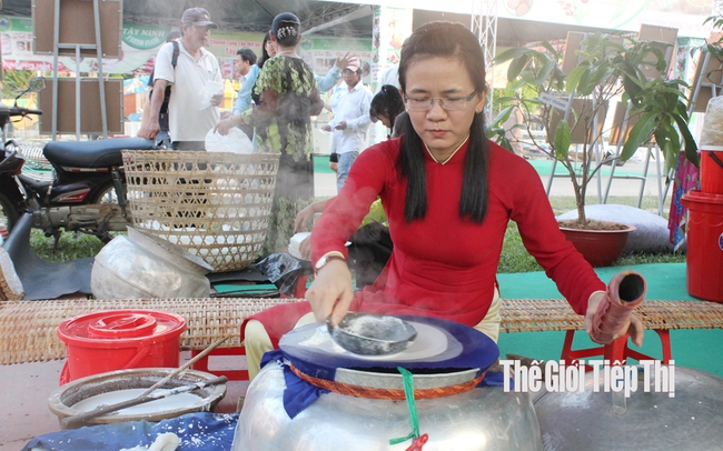 Bạn trẻ thích thú trải nghiệm nghề làm bánh tráng truyền thống. Ảnh: Trần Khánh