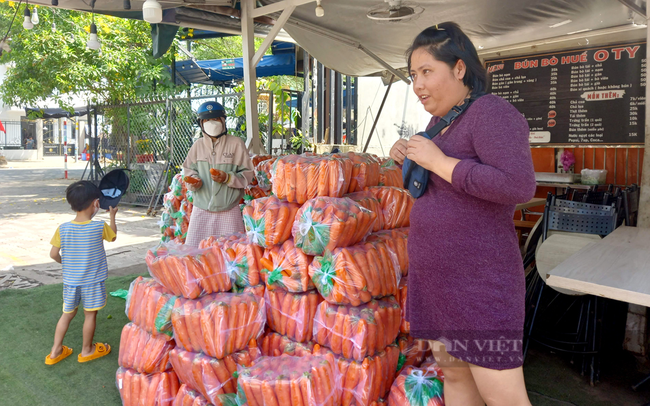 Tại cửa hàng bún bò Huế O Ty, bên cạnh chợ đầu mối nông sản Thủ Đức, chủ hàng rau kể, bị tồn hơn 10 tấn cà rốt, phải đăng thông tin biếu tặng cho những ai có nhu cầu. Ảnh: Nguyên Vỹ