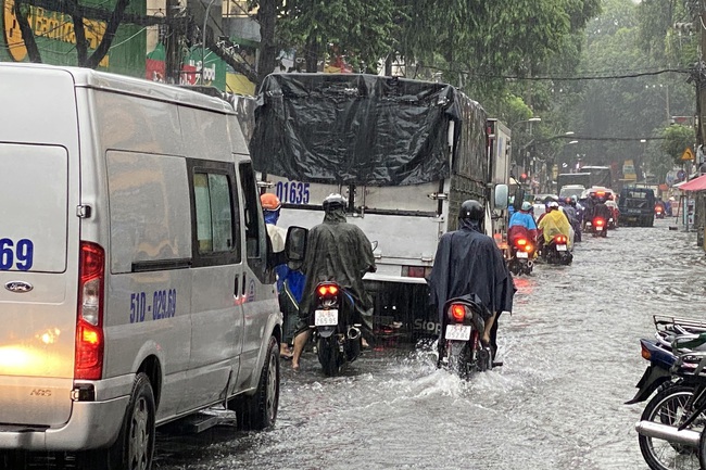 TP.HCM: Người dân chật vật lội nước, đội mưa đi làm trong ngày đầu tuần - Ảnh 1.