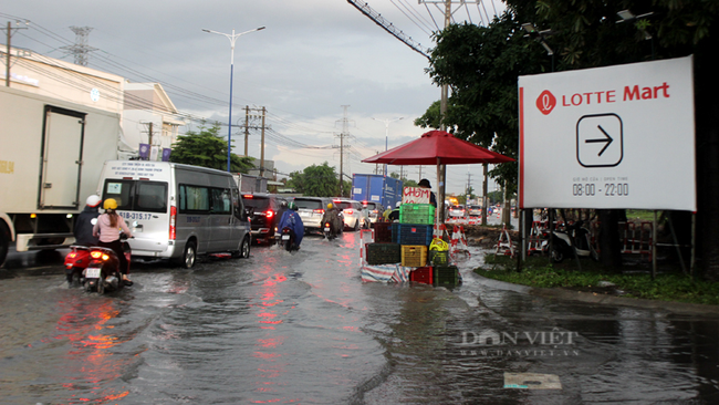 Bình Dương: Người dân khó nhọc lội nước ngập trên Quốc lộ 13 sau cơn mưa lớn - Ảnh 4.
