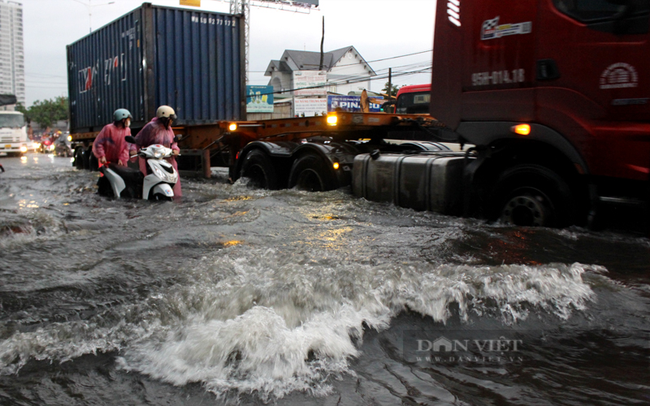 Bình Dương: Người dân khó nhọc lội nước ngập trên Quốc lộ 13 sau cơn mưa lớn - Ảnh 11.