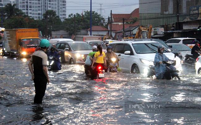Bình Dương: Người dân khó nhọc lội nước ngập trên Quốc lộ 13 sau cơn mưa lớn - Ảnh 13.