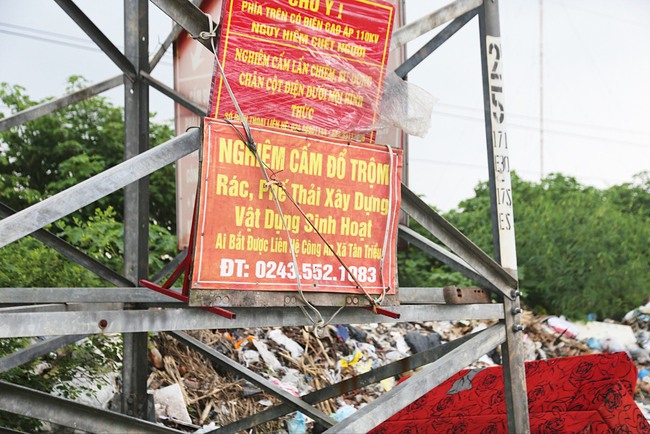 Rác thải bên cạnh các tấm biển cảnh báo cấm đổ rác ở Hà Nội - Ảnh 1.