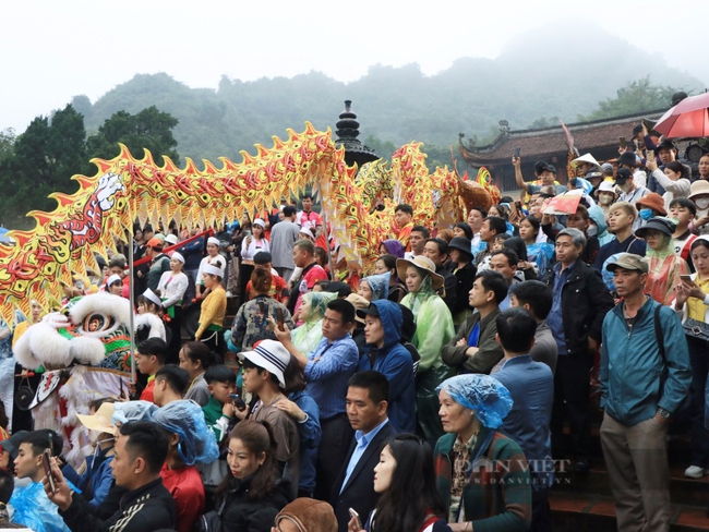 Hàng nghìn người đội mưa, tranh nhau hứng tiền "lộc" tại lễ khai hội chùa Hương 2024- Ảnh 1.
