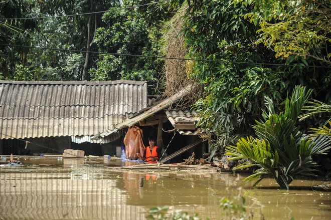 Bơi thuyền cứu trợ người dân bị cô lập do mưa lũ - Ảnh 1.