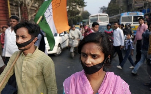 Các nhà hoạt động của đảng Quốc đại Ấn Độ với dải băng đen trên miệng biểu tình phản đối vụ thiếu nữ 16 tuổi bị cưỡng hiếp rồi thiêu sống. Ảnh: AP.