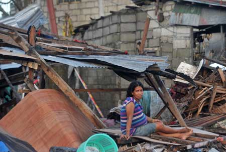 Một người phụ nữ  Tacloban với gương mặt buồn bã trước ngôi nhà bị siêu bão phá hủy.