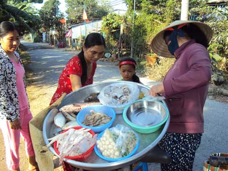 Nhiều người vẫn vô tư mua thịt gia cầm ở các “chợ lưu động” trong xã Tân Long. 