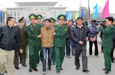 Đối tượng truy nã Trương Văn Hà được các lực lượng công an, biên phòng dẫn giải về Việt Nam.