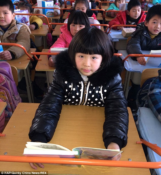  Trường tiểu học này ở Trung Quốc đã cài đặt các thanh trên tất cả các bàn học để giúp học sinh đọc sách ở một khoảng cách an toàn