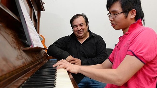 Dương Minh Tuấn (phải) và người bạn Australia Adrian De Luca, một thầy giáo dạy piano ở Melbourne. Ảnh: News Limited