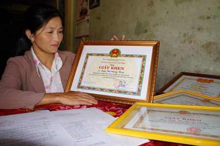 Nữ Trưởng thôn Trần Thị Chung Thủy bên giấy khen do UBND huyện Phú Ninh và xã Tam Lãnh trao tặng. 