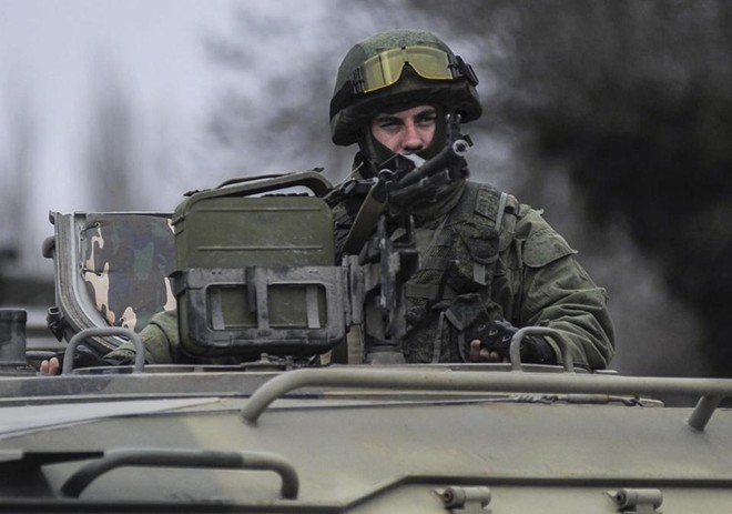 Một lính vũ trang ngồi trên xe bọc thép để canh gác trụ sở của lực lượng tuần duyên Ukraina ở ngoại ô thành phố Sevastopol, bán đảo Crimea hôm 1.3. Ảnh: AP