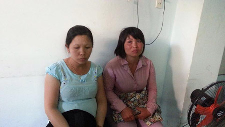 Nguyễn Thị Hồng (áo xanh), mang bầu 6 tháng và Lê Thi Thanh (áo hồng) tại cơ quan công an.