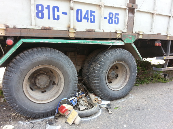 Chiếc xe máy hiệu Future bị cuốn vào gầm xe tải, nát bét.