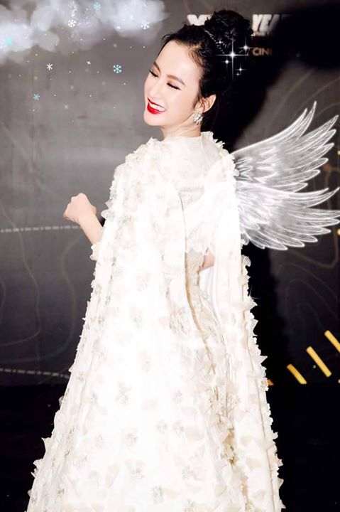 Người mẫu váy trắng tinh khôi đeo cánh thiên thần trên sàn diễn