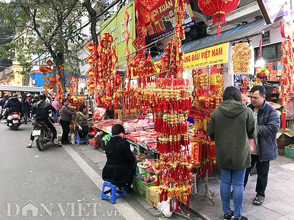 Vỉa hè trên phố Hàng Mã hoàn toàn phải nhường chỗ lại cho các sạp hàng Tết nhiều màu sắc. Người đi bộ buộc phải chen nhau với các xe máy di chuyển dưới lòng đường.