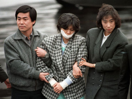 Kim Hyun-Hee (giữa) bị các nhà điều tra Hàn Quốc áp giải sau khi được dẫn về Seoul ngày 15/12/1987.
