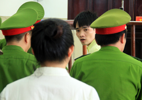 Trước giờ bị tòa tuyên án chung thân, Tân luôn đưa mắt nhìn người vợ thứ ba cùng lời động viên gắng cải tạo để ra tù chăm sóc con. Ảnh: Nguyễn Đông