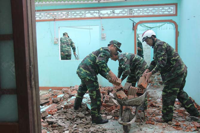 Bộ đội, dân quân tự vệ giúp dân dọn dẹp nhà cửa.