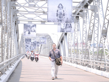 Ông Sébastien Laval và những bức ảnh về 54 dân tộc Việt Nam được treo trên cầu Trường Tiền. 