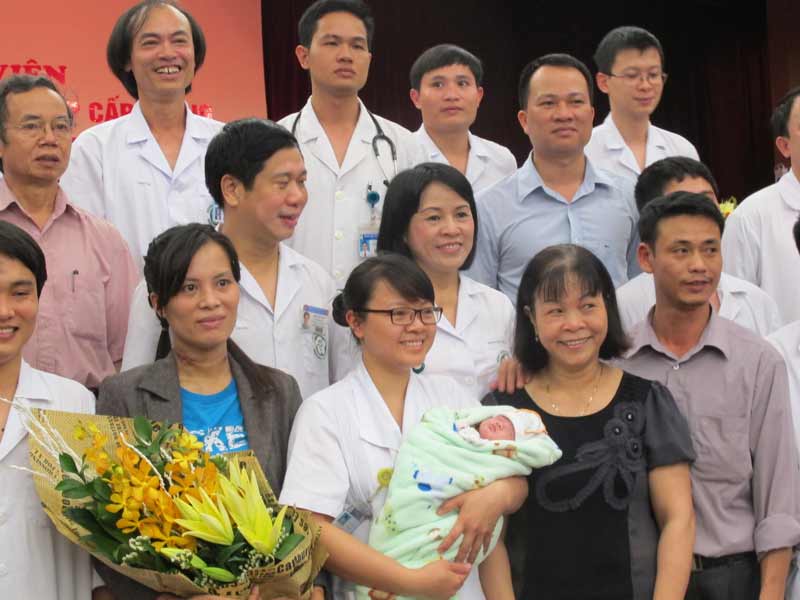 Hai mẹ con chị Hương (ôm hoa) cùng ê kíp thực hiện ca cấp cứu. 