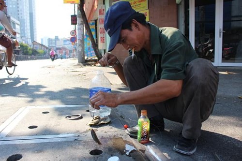 Anh Nguyễn Văn Bảy ngồi câu cá ở nắp cống hộp ngay đoạn giao nhau giữa Ngô Văn Sở và Nguyễn Tất Thành, bất chấp sự nguy hiểm