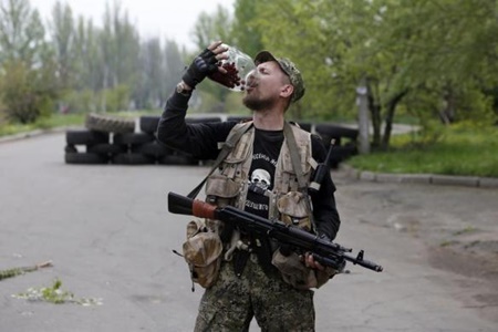 Một dân quân tự vệ địa phương đang ăn anh đào tại ột trạm kiểm soát gần một căn cứ không quân ở thành phố Kramatorsk ngày 2.5.