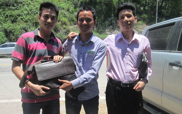 Anh Đào Hữu Ý (đứng giữa) đang trao lại chiếc túi cùng số tiền và giấy tờ cho anh Jiang (ngoài cùng bên trái)