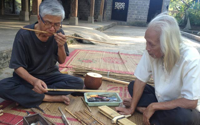 Ông Lò Văn Biến (phải) và ông Cầm Ngoan đang làm nhạc cụ khèn bè cho đêm múa xòe của bản.