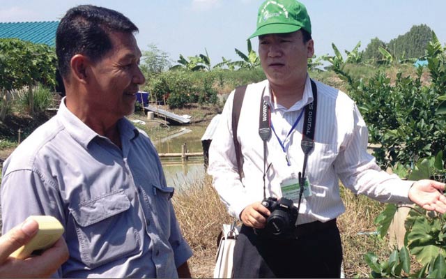 Huỳnh Quang Vinh đang trao đổi với nông dân Thái Lan về kỹ thuật canh tác. Ảnh: TL