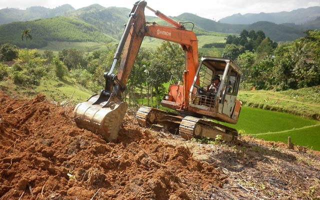 Đưa cơ giới vào làm đất tại khu vực núi chọn làm cánh đồng mẫu. 