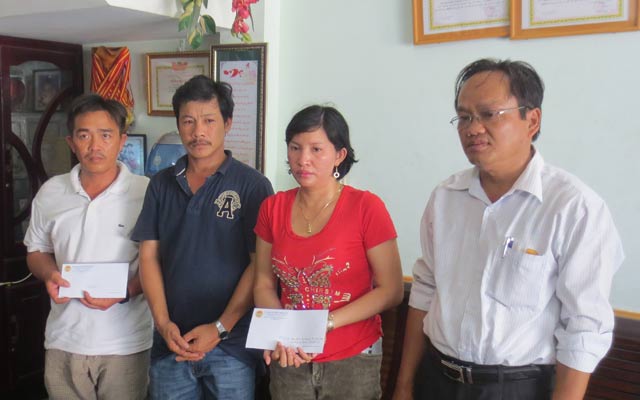 Ông Nguyễn Phú Ban (trái) trao tiền cho gia đình bà Hoa.