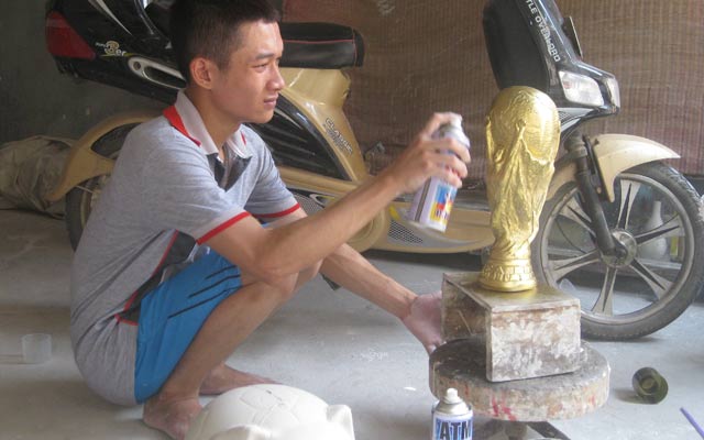 Phùng Quang Minh đang hoàn thiện khâu sơn màu cho chiếc Cúp vô địch thế giới.