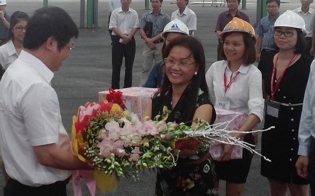 Bà Phạm Thị Nụ - Phó Tổng Giám đốc Tân Hiệp Phát tặng hoa cho đoàn công tác Bộ Công Thương thăm Nhà máy Number One Hà Nam. 