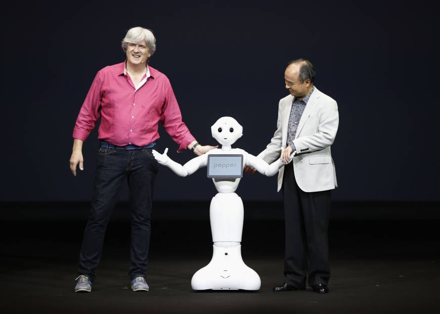 Giám đốc điều hành SoftBank Masayoshi Son (phải) và Giám đốc điều hành hãng người máy Aldebaran Robotics cùng giới thiếu robot mới Hạt Tiêu tại buổi họp báo ở Urayasu. 