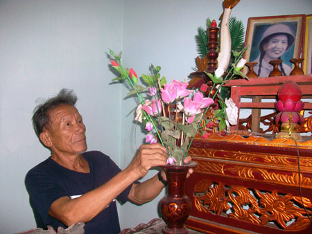 Ông Hồng bên bàn thờ liệt sĩ Võ Thị Tần được đặt trang trọng trong nhà mình.    