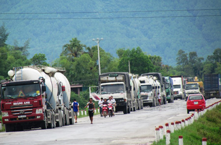 Hàng trăm xe tải dừng đỗ trên QL 1A để chờ thời điểm vượt trạm cân di động tại Hà Tĩnh.       