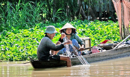 Người dân đánh bắt cá trên kênh rạch ở Vườn quốc gia Tràm Chim.    