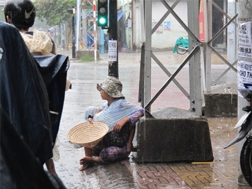 Người phụ nữ ôm đứa bé dầm mưa nhiều giờ liền