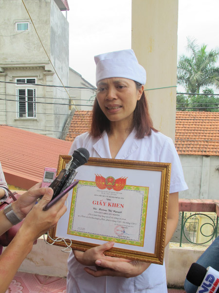 Chị Hoàng Thị Nguyệt – người tố cáo sai phạm của bệnh viện Hoài Đức, nhận bằng khen trong nước mắt. 