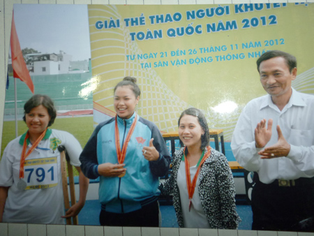 Chị Cho (bìa trái) nhận HCB tại Giải thể thao người khuyết tật toàn quốc năm 2012