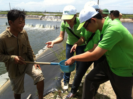 Lưu Quản Trọng (phải) cùng các Đại sứ  Môi trường Bayer 2013 tham quan ao nuôi tôm tại xã Lộc An (huyện Đất Đỏ, Bà Rịa - Vũng Tàu). 