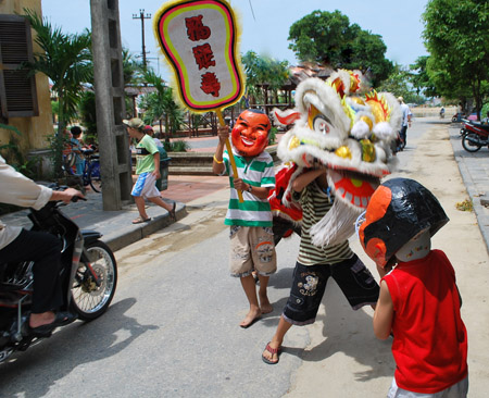 Các em tập múa lân ngay giữa đường, dễ dẫn đến tai nạn giao thông.    