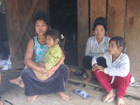 Mẹ con chị Liên (bên trái) trước căn nhà trống, xác xơ bởi đói nghèo.  