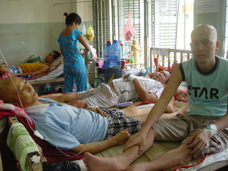 Bệnh nhân ung thư phải chia nhau “kẻ lộn đầu, người lộn đuôi” trên giường bệnh tại Bệnh viện Ung Bướu TP.HCM. Ảnh: Quốc Ngọc