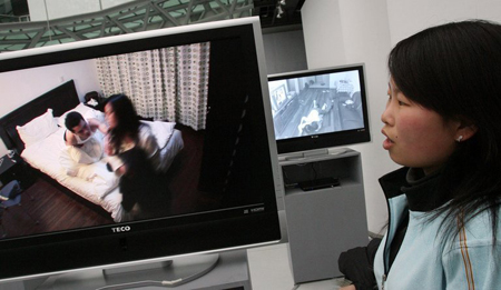 Một thiếu nữ TQ xem video nói về hôn nhân tan vỡ tại một cuộc triển lãm ở Thượng  Hải (TQ)