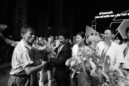 Nhà báo Hoàng Trọng Thủy tặng hoa chúc mừng nhóm tác giả NTNN đoạt giải A Báo chí quốc gia năm 2008.    