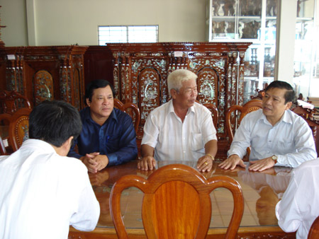 Phó Chủ tịch Lại Xuân Môn (phải) thăm một hộ sản xuất giỏi ở Tiền Giang. 