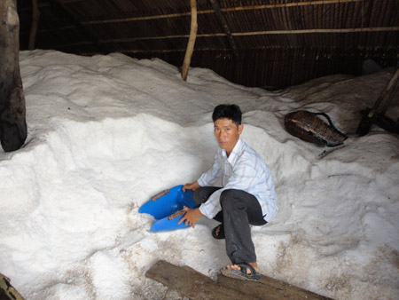 Anh Mai Thế Cầu bên kho muối sản xuất theo mô hình muối trải bạt của gia đình.